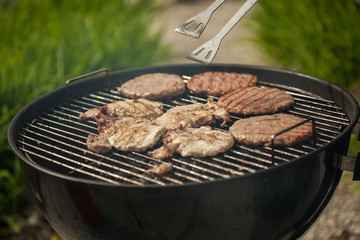 Person cooking steaks on a BBQ grill