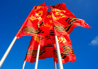 Red-yellow flags of the Victory developing on  background  blue sky.