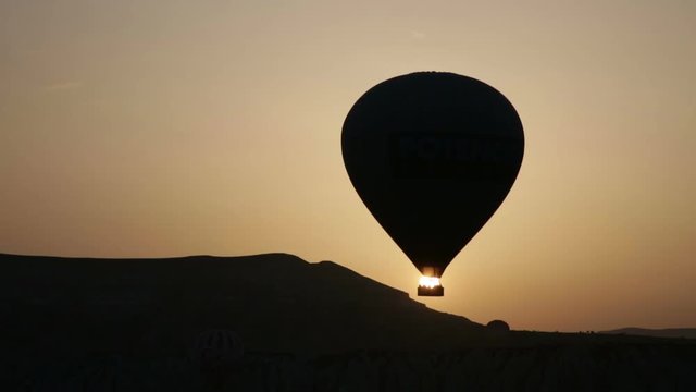 Balloons fly against the sun during sunrise, Cappadocia
