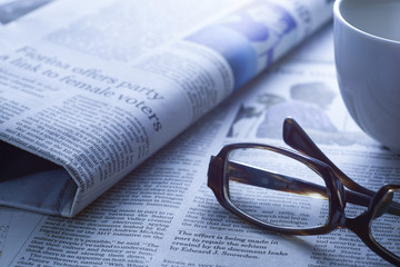Coffee over newspaper, blue tone