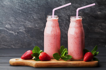 Strawberry smoothie or milkshake in jar on black rustic background, healthy food for breakfast and...