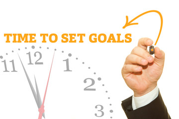 Businessman hand writing TIME TO SET GOALS message on a transparent wipe board.