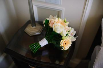 Wedding bouquet on the nightstand. Elegant black dresser and Bridal bouquet on it