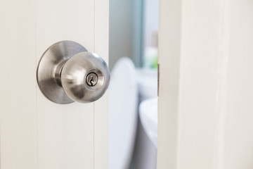 Close-up stainless door knob, with door open slightly