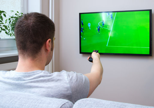 Man Watching Football Match On Television At Home.