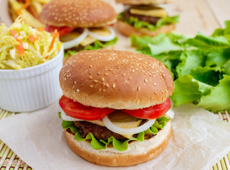 Sandwich home of the hamburger buns soft, juicy burger, cheese, tomato, parsley. Salad savoy cabbage. Fast food.