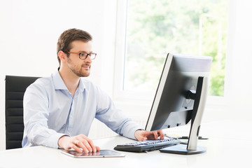 Young and confident businessman working in a modern office