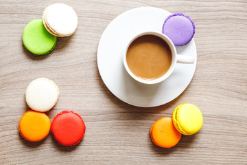 sweet breakfast with coffee and macaroons on wooden table