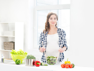 Pregnant woman preparing dieting food in the kitchen