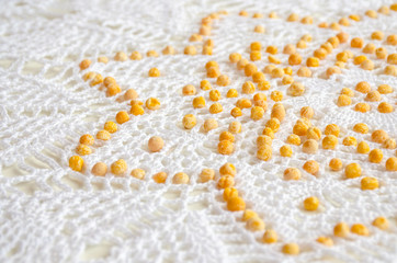 ornament peas laid out on the crocheted tablecloth