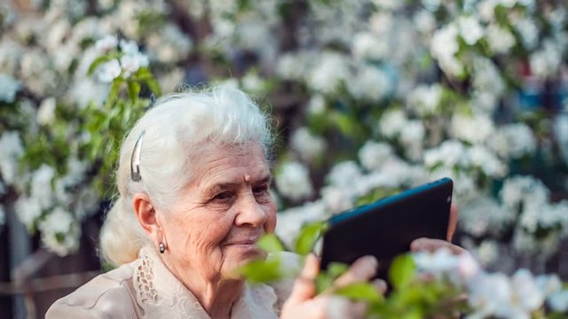 Elderly woman shoots video on tablet