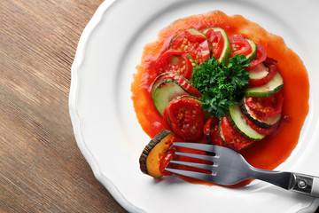 Ratatouille on plate, on table background
