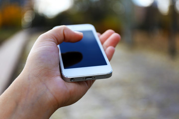 Woman holding smartphone outside