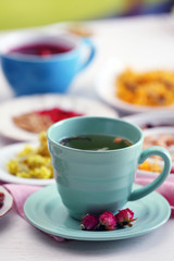 Cup of tea with aromatic dry tea on wooden background