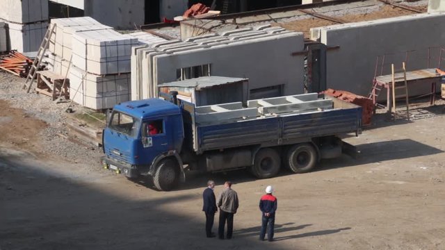 PERM, RUSSIA - SEP 28, 2015: Trucks and guiding people on construction site of largest developer Perm factory of silicate panels