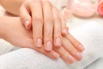 Woman hands with beautiful manicure on towel, close up