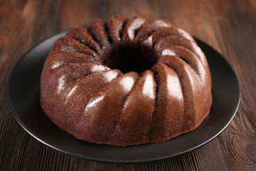 Chocolate cake on black plate on wooden background