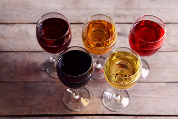 Glasses with wines of different colors on a wooden table
