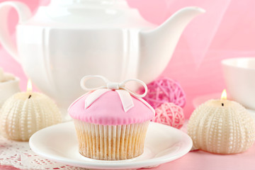 Tasty cupcakes with tea set and decorations, closeup
