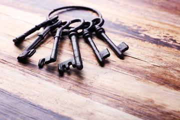 Bunch of old keys on wooden background, close up