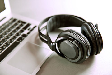 Headphones and laptop on table closeup
