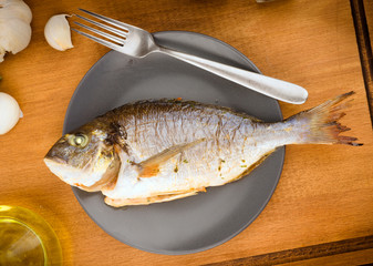 Vertical making whole roasted golden on plate, on wood