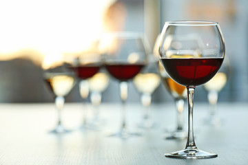 Glasses of wine on light blurred background