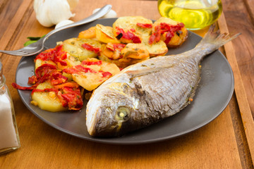 roasted sea bream with potatoes on wooden