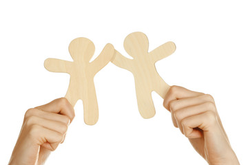 Hands holding a couple of wooden figures, isolated on white
