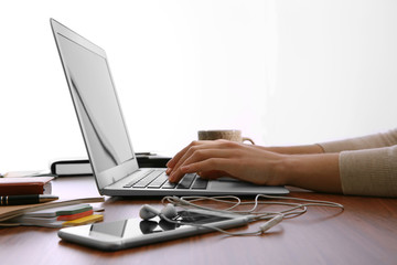 Fototapeta premium Female hands working with a laptop in the office on window background