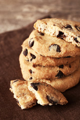 Chocolate chip cookies on a brown napkin on wooden table