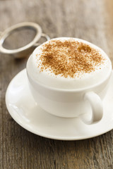 Cappuccino in white cup with cinnamon