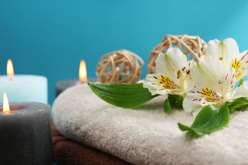 Obraz na płótnie Canvas Spa set: soft towel, flowers, massage oil, candles, sea salt, close up