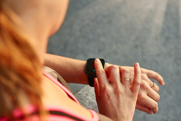 Fototapeta premium Woman programming her smartwatch before going jogging to track performance