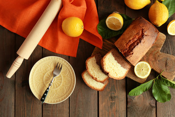 Delicious sweet cake bread with lemons on wooden table, top view