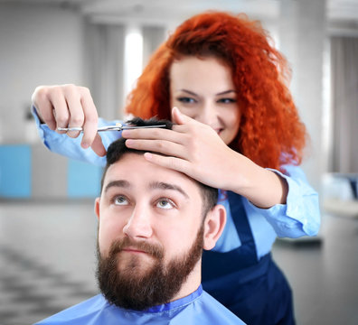 Professional hairdresser making stylish man haircut