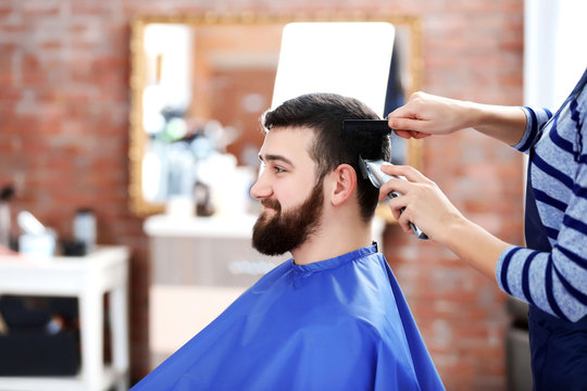 Professional hairdresser cutting hair with hair clipper