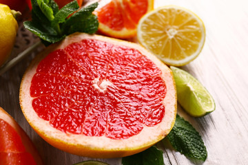 Pieces of different citrus fruit on light wooden table