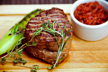 Beautiful juicy well done steak with sauce on a wooden Board