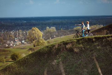 Beautiful young couple in love on bicycles on the walk come from the mountains