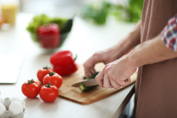 Obraz na płótnie Canvas Man chopping vegetables in kitchen