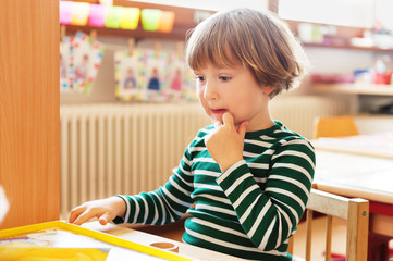 Indoor portrait of a cute little boy in a classroom