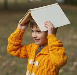 funny boy with book on his head