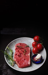 Raw striploin beef steak on black background