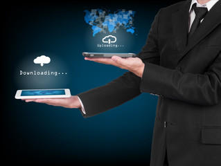 Businessman with modern mobile phone uploading data in his hand