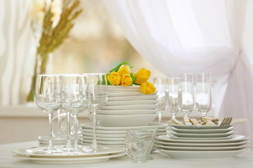 Set of dishes with yellow tulips for dinner party