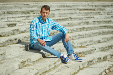 young hipster boy sitting on stairs