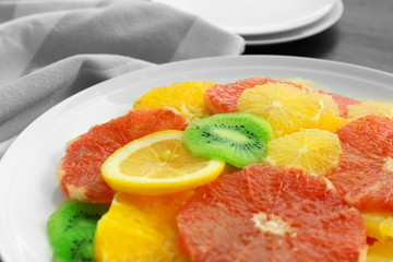 Plate of fresh peeled and sliced citrus, closeup