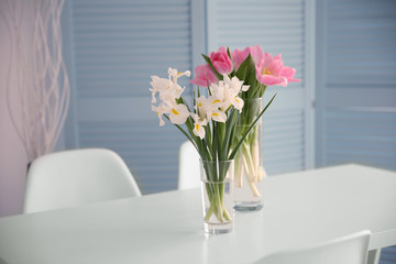 Beautiful tulips and irises on dinning table , indoors