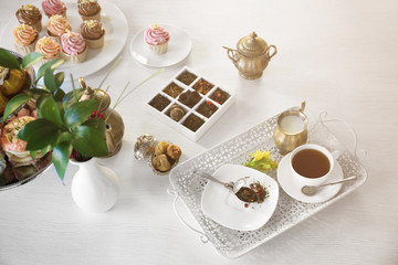 Delicious tea and cakes on wooden background